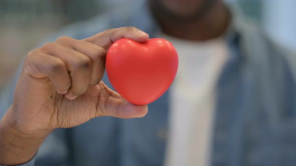 Close Up of African Man Holding Heart Shape Object