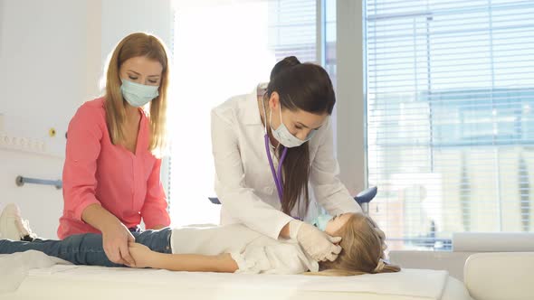 Friendly Pediatrician in Mask Hold Checkup