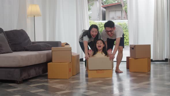 Happy Asian young family having fun laughing moving into new home