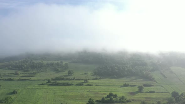 Mist spreading over the hills and forest 4K aerial video