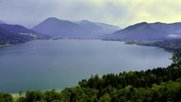 Aerial view over the beautiful Tegernsee at sunshine and light sunbeams, flying down the drone as cr