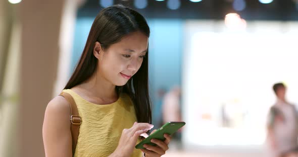 Young woman use of mobile phone in the city at night