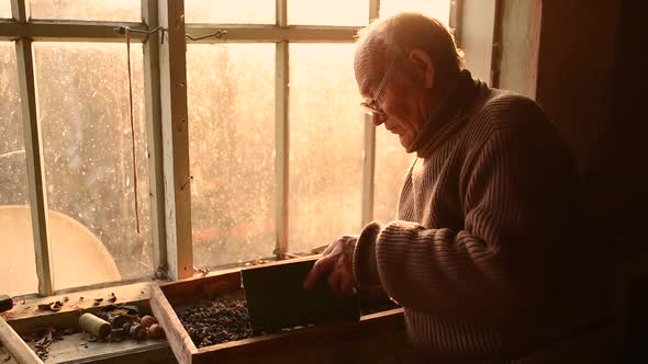 Man Glasses Picks Up Old Book in Dust Read in House Window