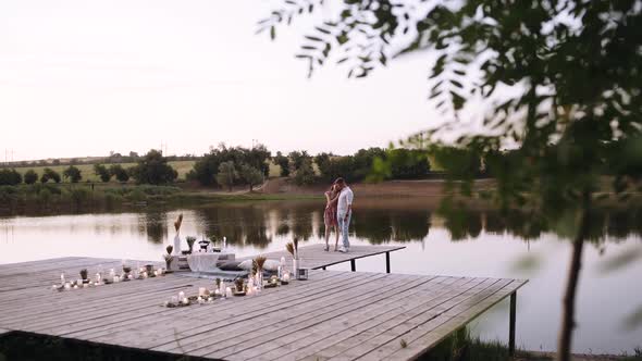 Couple in Love Walk Hugging and Happy on a Wooden Deck.