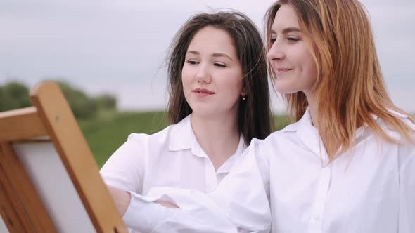 Elegant and Beautiful Girls Painting in a Field