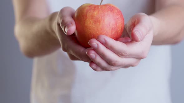 Closeup Image of a Woman Holding and Giving a Red Apple