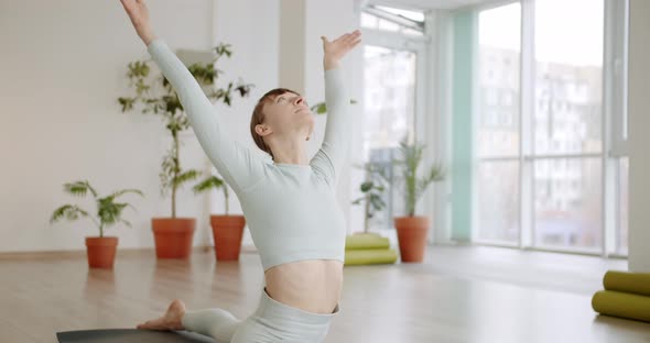 A Beautiful Woman Practices a Spagat Exercises in Bright Studio Anjaneyasana