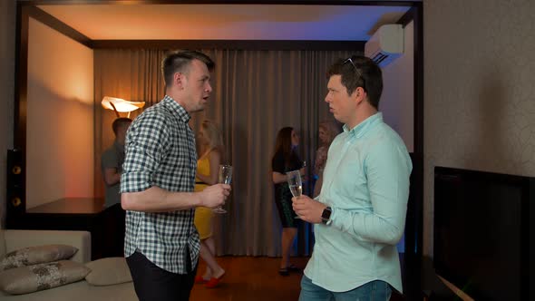 Male Friends Drinking Champagne and Chatting in the Apartment Party