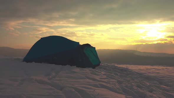 Hiker getting out from tent, enjoying cold weather