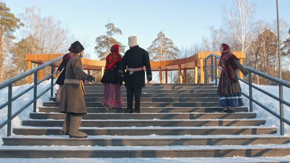 Russian Folk - People in Traditional Russian Clothes Are Dancing on the Stairs in Winter