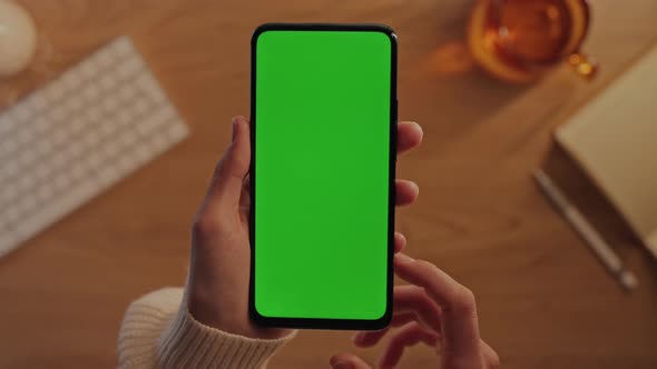 Female Hands Sliding on Green Screen of Modern Mobile