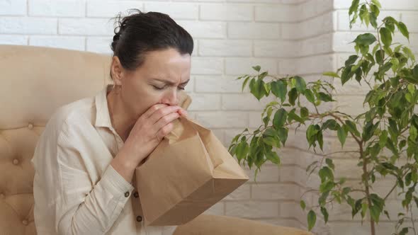 Sick woman breathe into the bag.