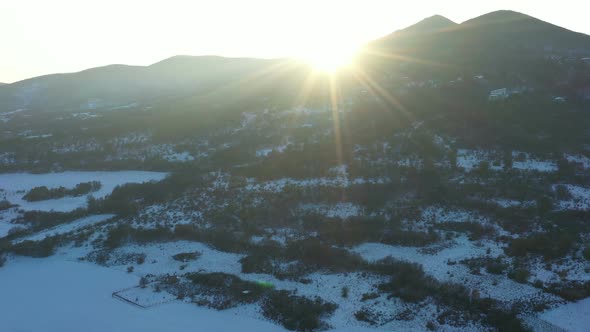 Flight Over Aida Peak In Bulgaria On A Winter Snowy Day At Sunset