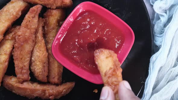 Top View of Man Hand Eating Potato Wedges.