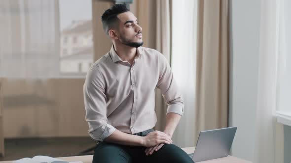 Thoughtful Young Man Sad Professional Worker Sitting on Desk Looking Out Window Deep in Thoughts