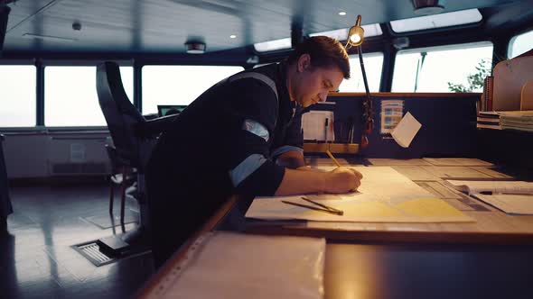 Marine Navigational Officer During Navigational Watch on Bridge . He Does Chart Correction