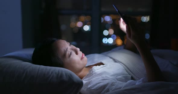 Woman use of mobile phone at home in the evening