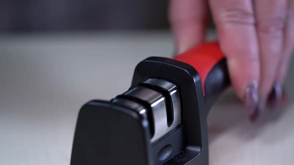 A Man Sharpens a Knife with a Whetstone Closeup