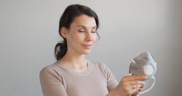 Young Woman Shows How To Wear Protective Medical Mask. Beautiful Girl Shows Protective Mask During