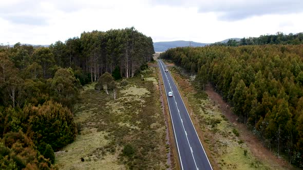 Aerial follow of Van on empty country road in Tasmania. Mobile home, backpacking Tasmania, Australia