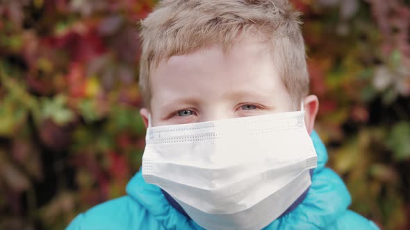 Pandemic Portrait of Little Boy in Protective Medical Mask on Street in City