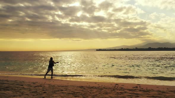 One boy angler on paradise island beach journey by blue sea with white sand background of Indonesia 