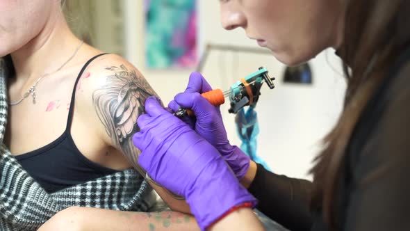 Tattoo artist tattooing an arm