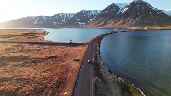 Drone Of Car Driving On Road Over Fjords Towards Mountains