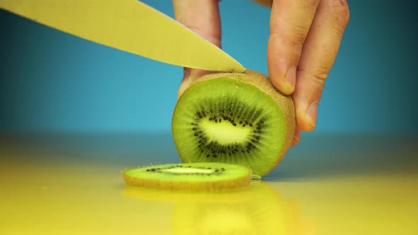 Horizontal Shot of Male Hands Cutting Kiwi Fruits