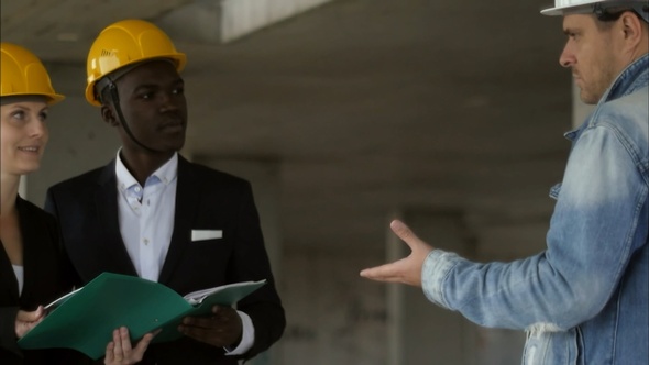 Side View of Handsome Construction Team in Protective Helmets