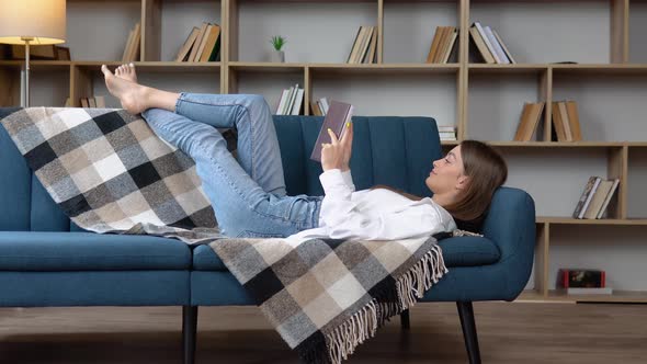 Close Up of Lying Woman Reading Book Relaxing at Home