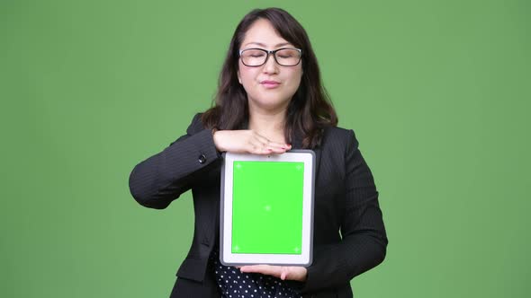 Mature Beautiful Asian Businesswoman Showing Digital Tablet