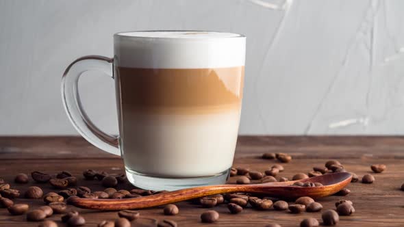 Cup of hot coffee latte on a wooden table, morning time