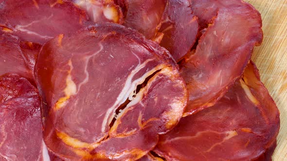 Air dried pork loin slices, macro shot view from above, rotating motion. Close up view in 4k of trad