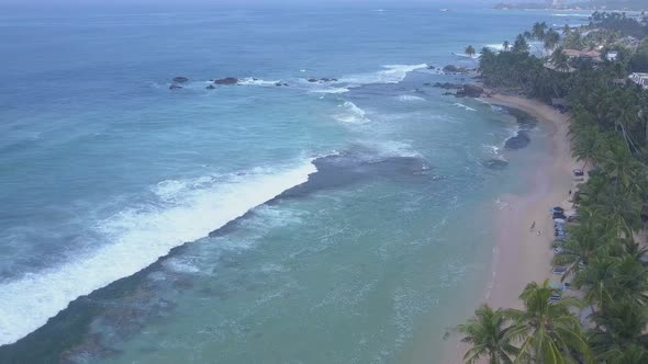 Yellow Sandy Coastline Between Palm Trees and Ocean