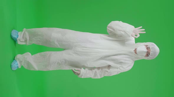 Asian Man Wear Protective Uniform PPE And Showing Hand Ok Sign In The Green Screen Studio