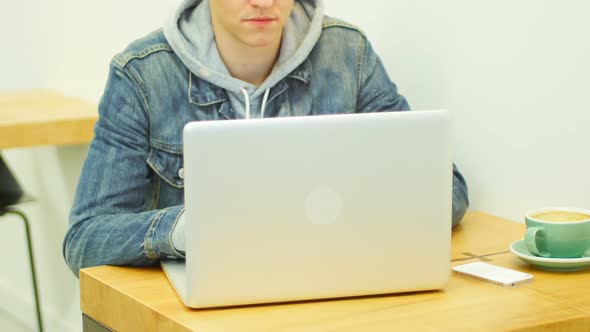 Man using laptop while having coffee