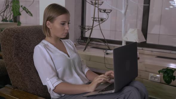 Female Typing on Computer in Cosy Room