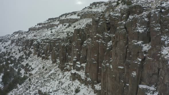 Slow drone pan of rocky snowy canyon