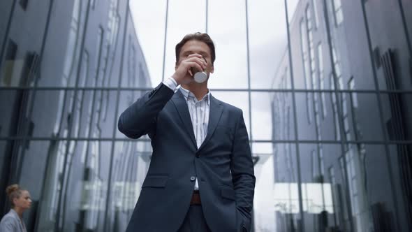 Portrait Smiling Businessman Drinking Coffee Standing at Glass Office Building