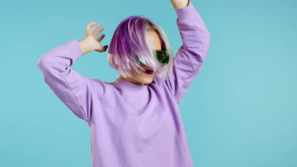 Hipster Woman Dancing Energetically, Actively in Glowing Glasses Isolated on Blue Background. Party