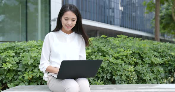 Asian woman use of laptop computer in city