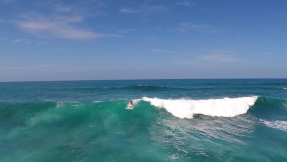 Aerial view of a man sup stand-up paddleboard surfing in Hawaii