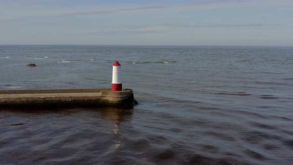 A Lighthouse and Breakwater at the Mouth of a Harbour in the UK