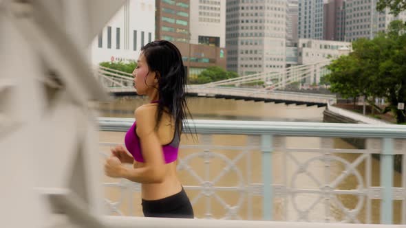 Middle-aged Asian woman jogging in the rain in Singapore 