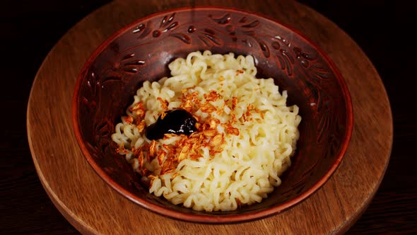 Readymade Instant Noodles with Condiment in Plate on Wooden Board