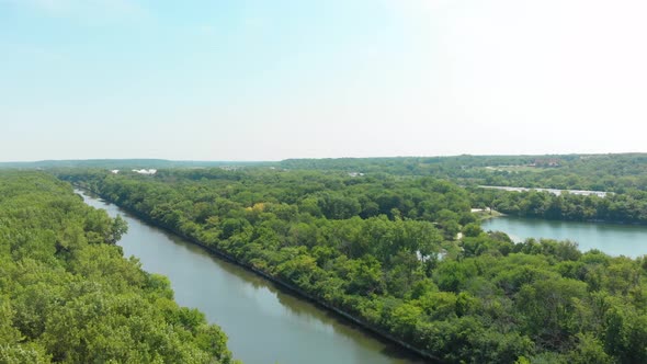 horizon aerial drone over shipping canal and thick forest 4k