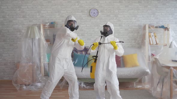 Two Workers Cleaning Service or Scientists in Protective Overalls Dancing