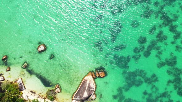 Tropical beach background. crystal clear azure seawater sandy beach with granite bulders. Aerial