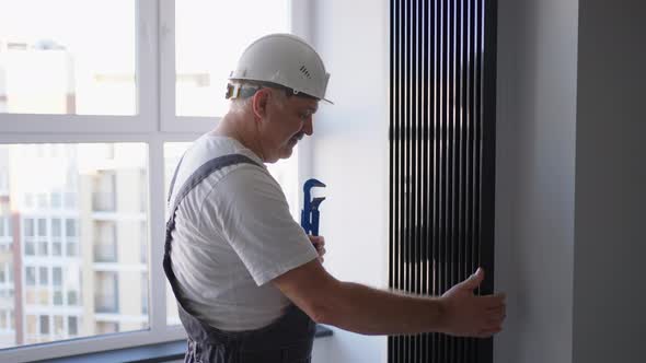 A Man Plumber Checks the Batteries and Heating System